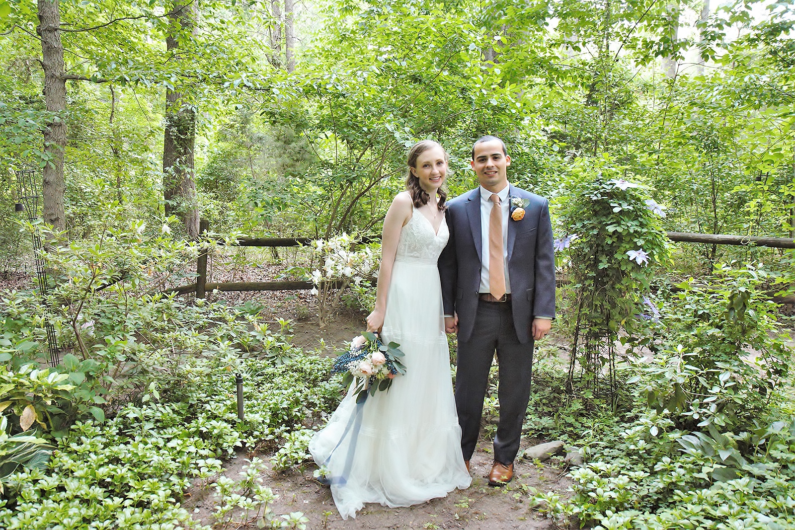 Bride and groom posing in garden.