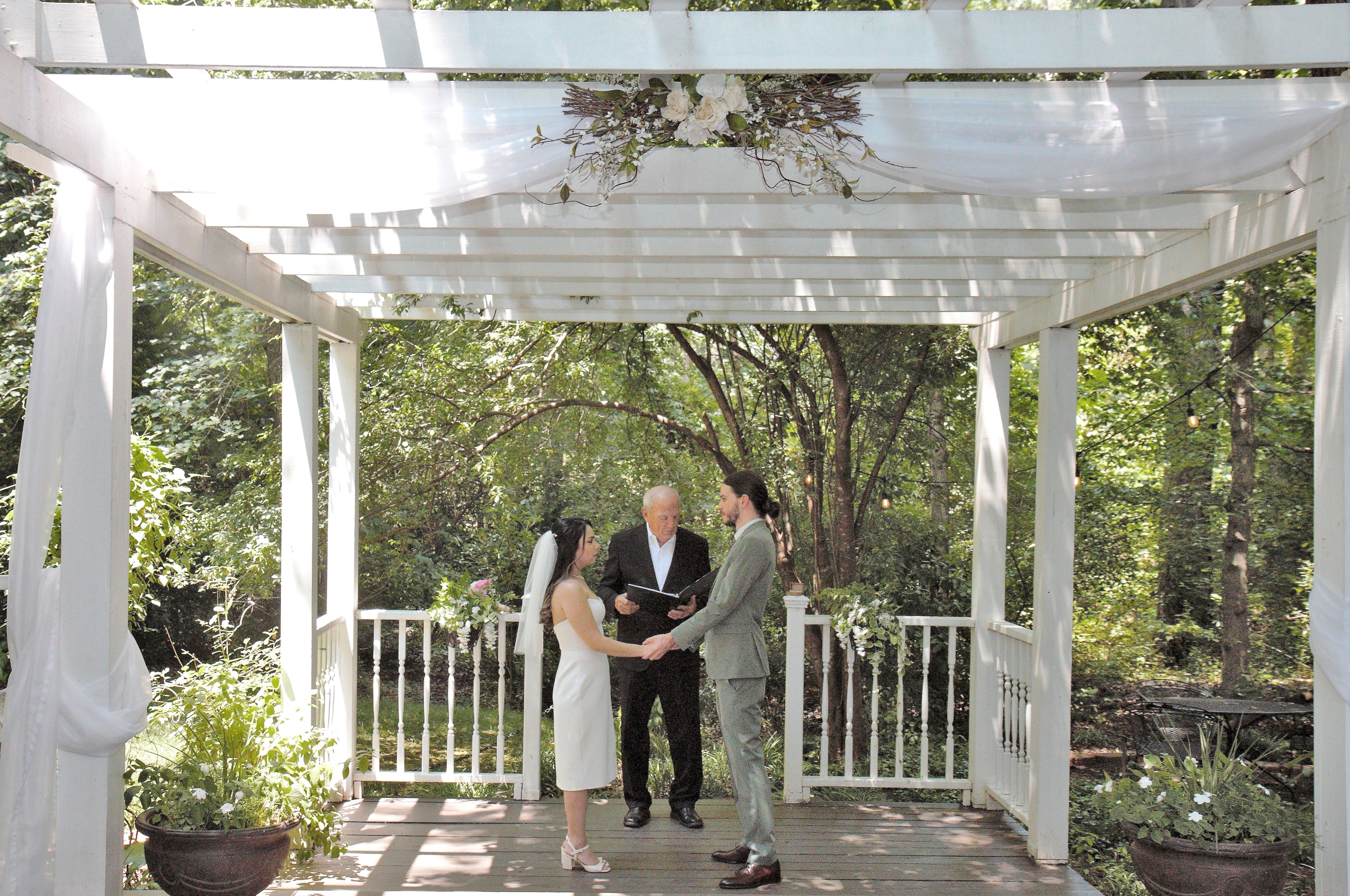 bride & groom with officiant during ceremony