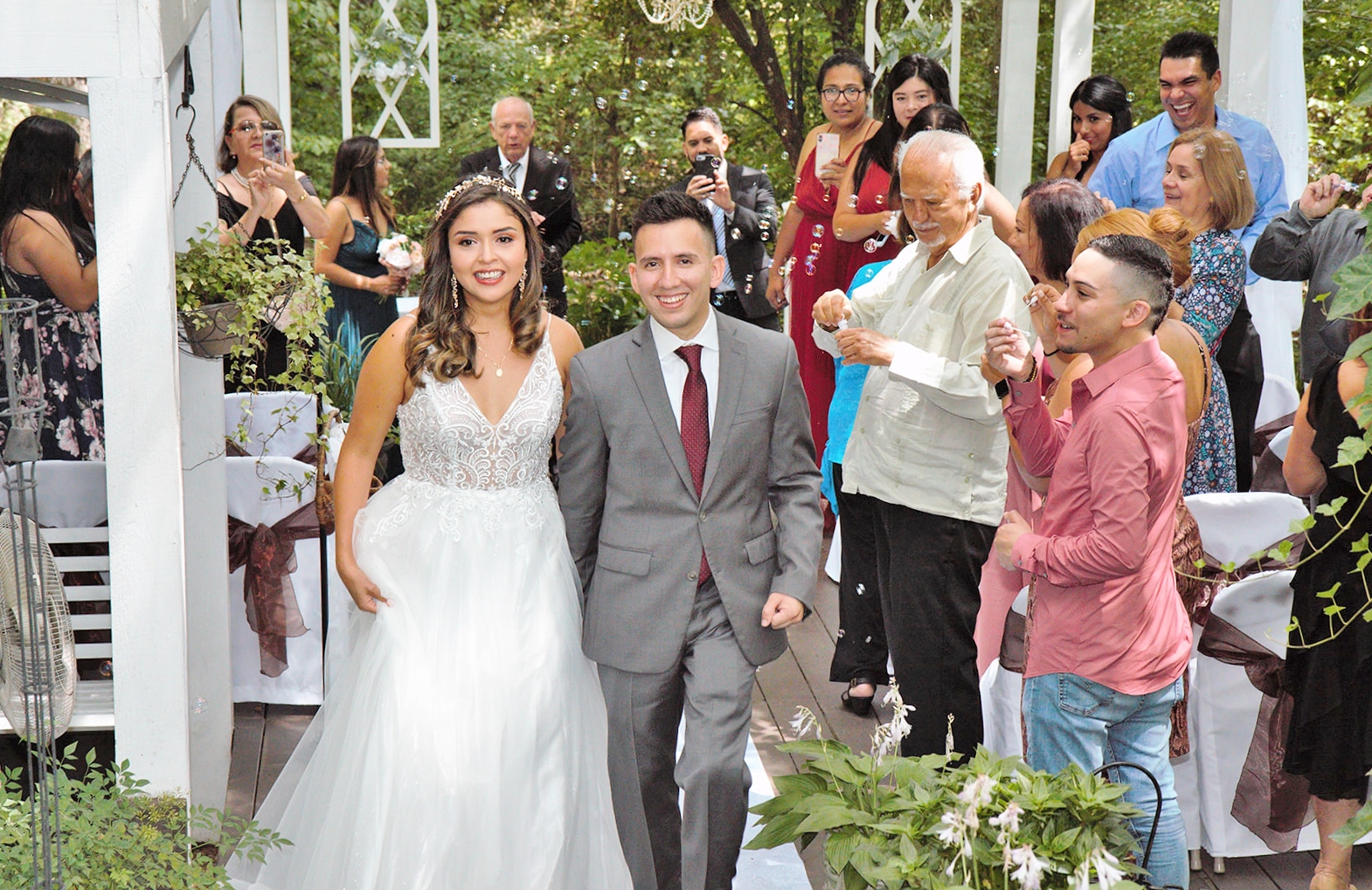 Bride and groom walk back up the aisle runner to ring the bell.