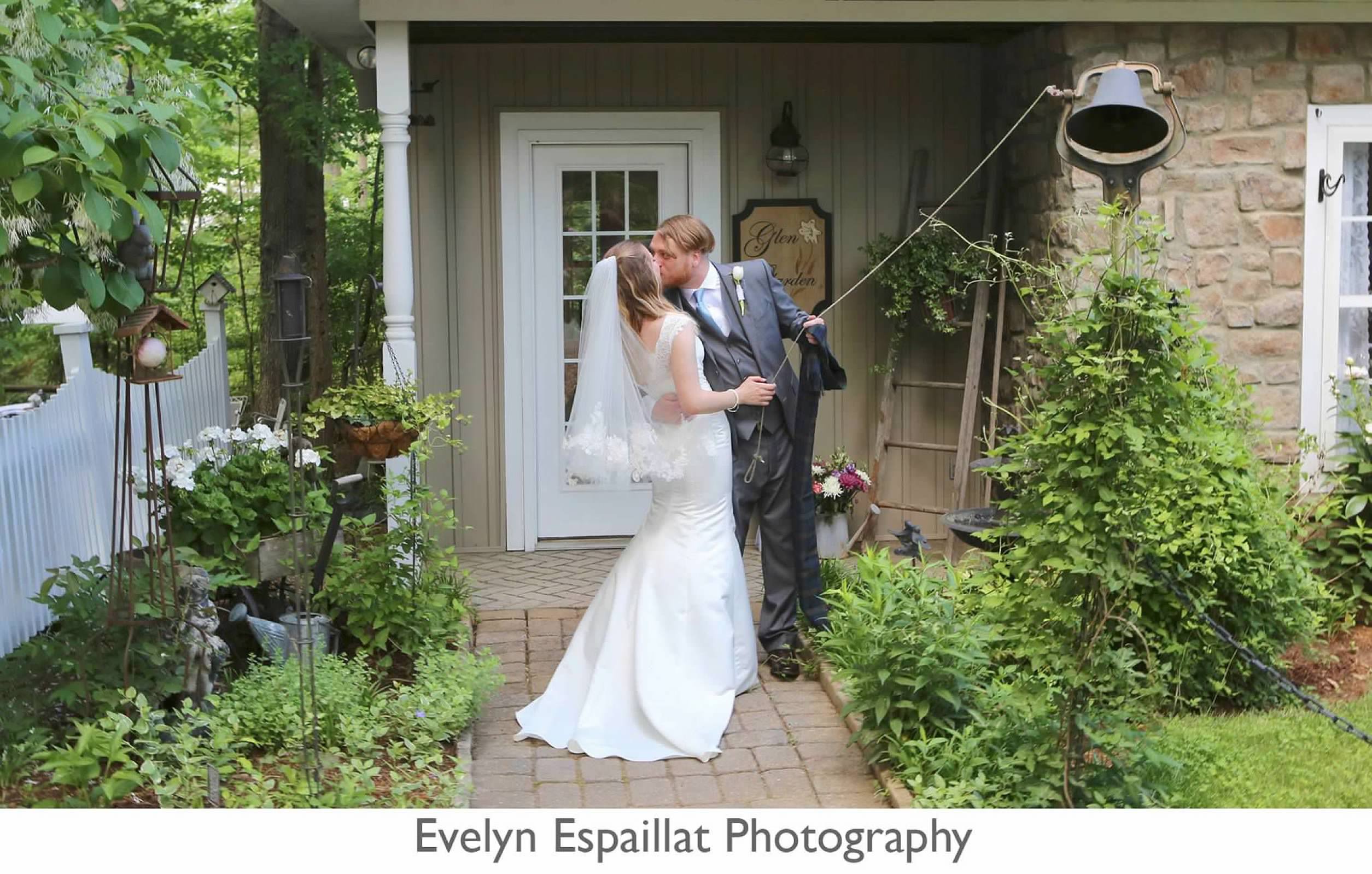 Bride and groom kiss while ringing the bell.